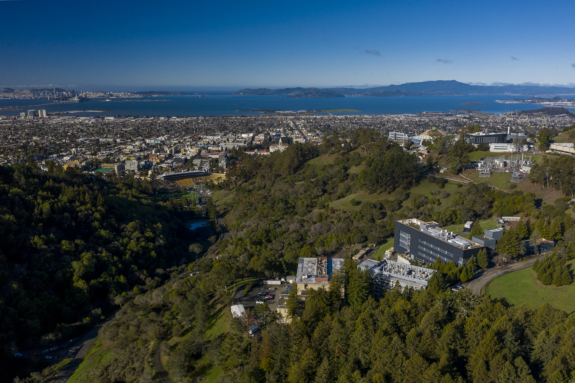 An aerial view of the National Energy Research Scientific Computing Center (NERSC) in the foreground, with the rest of the Berkeley Lab and the Berkeley Hills in the background